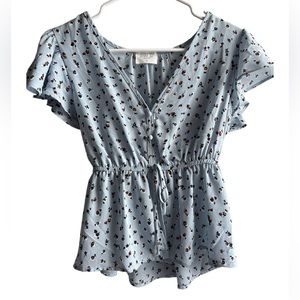 Blue blouse with flowers all over it